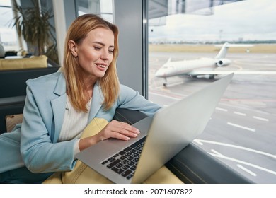 Traveler using her notebook computer in airport lounge