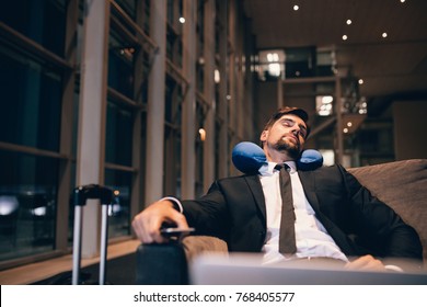 Traveler waiting at airport after flights delays and cancellations. Businessman asleep in airport lounge. - Powered by Shutterstock