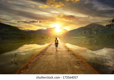 Traveler walking along the road to the mountains. - Shutterstock ID 173564057
