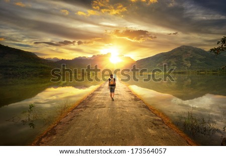 Traveler walking along the road to the mountains.