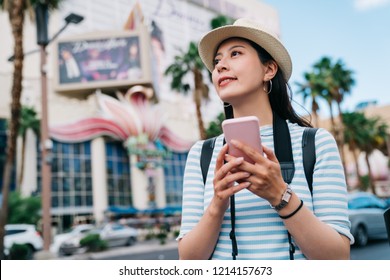 traveler walking on the street in Las Vegas and finding the way to casino. young lady hobby is a gambler using online map app cellphone to get the right direction. famous sightseeing spot in vegas.