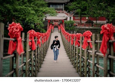 A traveler walks on an ancient suspension bridge in the dujiangyan scenic area of chengdu, China