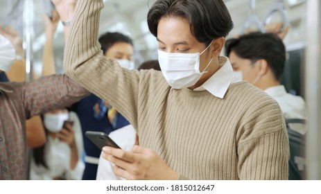 Traveler wearing face mask while using mobile phone on public train . Coronavirus disease or COVID 19 pandemic outbreak and urban city lifestyle problem in rush hour commuting concept . - Powered by Shutterstock