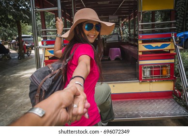 Traveler Woman With Backpack Holding Man By Hands Getting On Local Bus In Ranong, Travel In Thailand