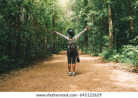 Traveler woman with backpack walking on path in the tropical forest, Krabi, Thailand