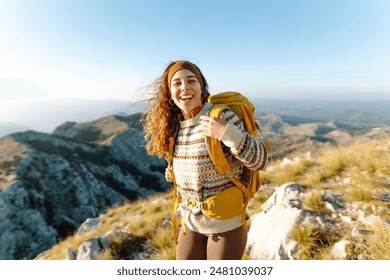 Traveler woman backpacker on mountains cliff hiking enjoy landscape. Hiking in the mountains with backpacks. Adventure active.