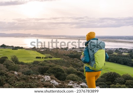 Traveler woman with her backpack admiring the landscape of Dublin Bay, Ireland