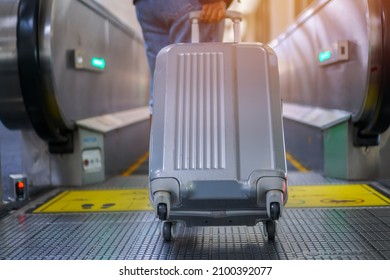 Traveler woman hold luggage on escalator at terminal airport or transit flight with suitcase in journey vacation holiday at elevator arrival international airport, Lifestyle by airplane in Asia