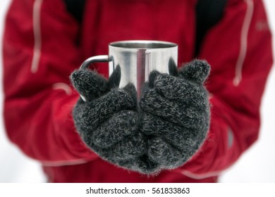 Traveler woman  holding cup of tea the outdoors. Adventure, travel, winter concept.