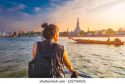 Traveler woman on boat joy view Wat Arun at sunset, Chao Phraya river, Famous water landmark travel Bangkok Thailand, tourist female on holiday vacation trips, Tourism beautiful destination place Asia