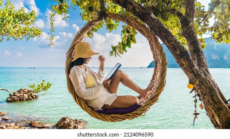 Traveler woman relaxing on straw nests using tablet at Railay beach Krabi, Asia business people on vacation at resort work with computer notebook, Tourist travel Phuket Thailand summer holiday trip - Shutterstock ID 2124096590