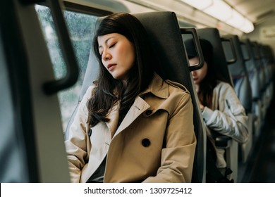 Traveler woman sleeping in a train travel beside the window. tired chinese lady worker in smart casual commute to work take a nap. young girl sitting on seat on subway fell asleep in quiet place. - Powered by Shutterstock