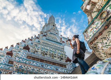 Traveler woman taking photo pagoda temple unique attractions in Wat Arun, Traditional culture famous landmark tourist travel Bangkok Thailand holiday vacation, Tourism beautiful destination place Asia