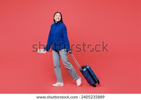 Traveler woman wear blue sweater casual clothes hold passport ticket bag look aside isolated on plain pink background. Tourist travel abroad in free time rest getaway Air flight trip journey concept