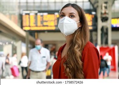 Traveler Woman Wearing KN95 FFP2 Face Mask At The Airport. Young Caucasian Woman With Behind Timetables Of Departures Arrivals Waiting Worried Information For Her Flight.