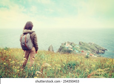 Traveler Young Woman Standing On Hill And Looking To The Town On Peninsula. Image With Instagram Filter