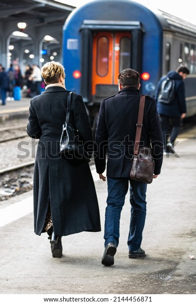 Travelers and commuters waiting\
for a train on the train platform of Bucharest North Railway\
Station (Gara de Nord Bucharest) in Bucharest, Romania,\
2022