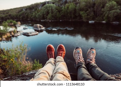 Travelers couple hiking boots on mountain near river on nature background. Man and woman family trekking shoes. Pair sitting and making feet selfie on beautiful landscape with forest. - Powered by Shutterstock