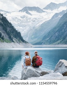 Travelers couple look at the mountain lake. Travel and active life concept with team. Adventure and travel in the mountains region in the Austria - Shutterstock ID 1154559796