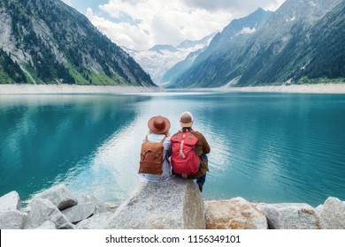 Travelers couple look at the mountain lake. Travel and active life concept with team. Adventure and travel in the mountains region in the Austria - Shutterstock ID 1156349101