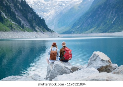 Travelers couple look at the mountain lake. Travel and active life concept with team. Adventure and travel in the mountains region in the Austria - Shutterstock ID 1196321884