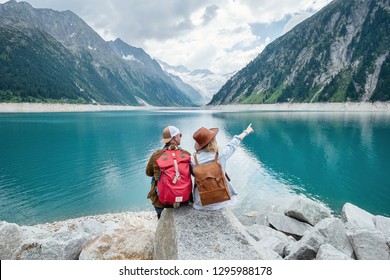 Travelers couple look at the mountain lake. Travel and active life concept with team. Adventure and travel in the mountains region in the Austria. Travel - image - Shutterstock ID 1295988178