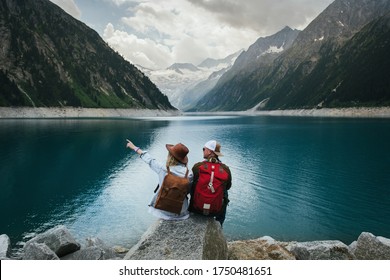 Travelers couple look at the mountain lake. People with a backpack travel. Adventure and travel in the mountains region. Zillertal Alps, Austria. - Shutterstock ID 1750481651