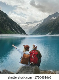 Travelers couple look at the mountain lake. People with a backpack travel. Adventure and travel in the mountains region. Zillertal Alps, Austria. - Shutterstock ID 1750481663