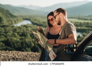 Travelers Couple on Road Trip, Man and Woman Using Map on Journey Near Their Car Over Beautiful Landscape - Shutterstock ID 1795606495