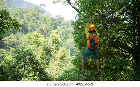 Travelers hung on a a wire rope over a vast forest, a fun and challenging activity, a zipline in bolaven plateau in southern Laos, hung over waterfall - Powered by Shutterstock