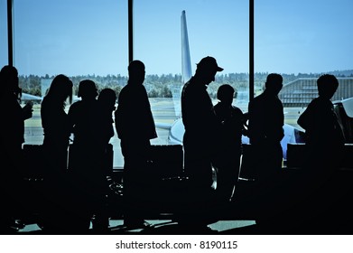 Travelers Standing In Line At The Airport Waiting To Board An Airplane