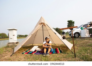 Travelers thai women people travel visit sit on carpet mat of cafe coffee shop outdoor and tent camping beside irrigation canal at Bangbuathong city rural countryside in Nonthaburi, Thailand