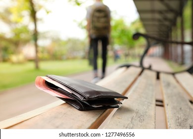 Traveler's wallet with money that was dropped on a chair in the park while the tourist is walking away. - Shutterstock ID 1277496556
