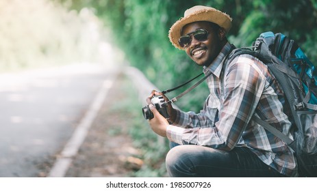 Traveling african male tourist backpackers taking photo side of the highway road.Adventure travel concept