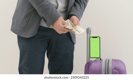 Traveling business man tourist with suitcase, smartphone chroma key green screen counting money in international airport, close up isolated on white background. - Powered by Shutterstock