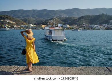 Traveling by Greece. Young happy woman waiting for sea taxi boat on the sea wharf.