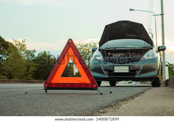 Traveling, but cars crash along the\
highway in the evening. Should open the hood and bring the\
emergency symbol to the ground to warn other cars to be\
careful.