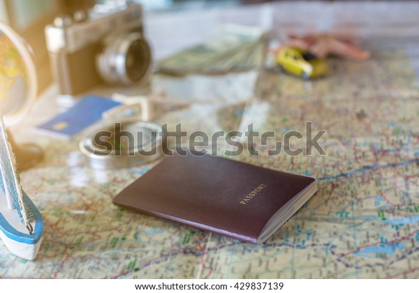 traveling concept accessories passport,\
money, starfish,camera,boat,  and map on wooden\
board