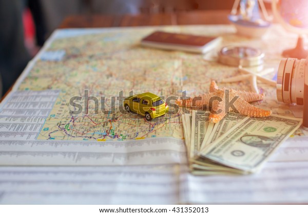 traveling concept accessories passport,\
money, starfish,camera,boat, and map on wooden\
board