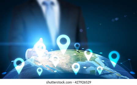 Traveling concept with businessman pointing at globe with location pin network on dark background. Elements of this image furnished by NASA