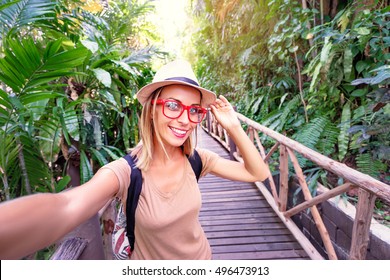 Traveling Concept. Technology And Adventure. Young Woman Taking Selfie In Jungle.