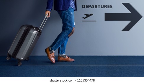 Traveling Concept, Young Traveler Walking with Suitcase and Follow the Departures Sign in the Airport