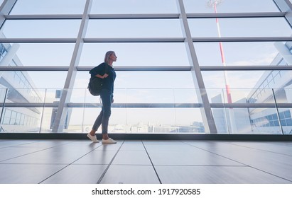 Traveling concept. Young woman in casual wear standing in international airport terminal waiting for boarding.