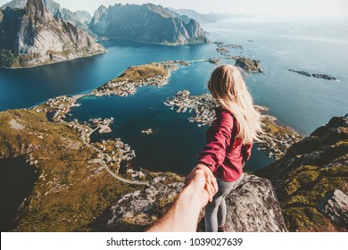 Traveling Couple follow holding hands on cliff mountain in Norway lifestyle concept summer vacations outdoor Lofoten islands Reinebringen - Powered by Shutterstock