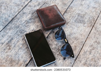 Traveling Essential Consists of Smart Phone, Wallet, and Sunglasses on Old Wooden Surface Background - Powered by Shutterstock