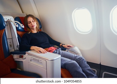 Traveling At First Class. Flight With Comfort. Pretty Young  Woman Sleeping In Airplane.