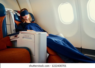 Traveling At First Class. Flight With Comfort. Pretty Young  Woman Sleeping In Airplane.