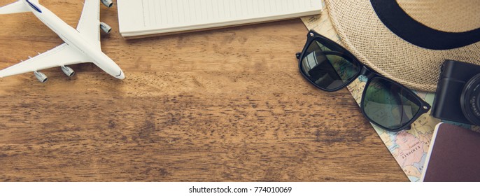 Traveling Gadgets Including Camera,  Map, Passport, Sunglasses And Airplane Model On Wood Table Background, Top View Border Design Banner With Copy Space