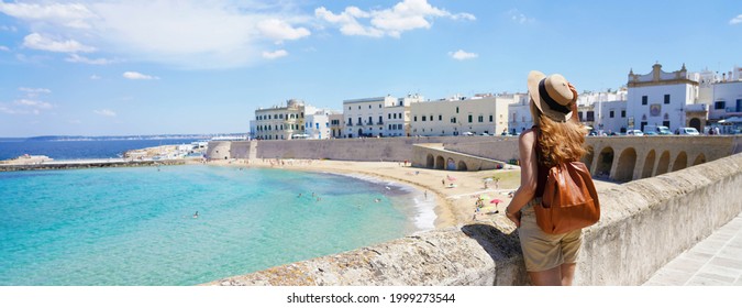 Traveling in Italy. Panoramic view of female backpacker with hat in Gallipoli village, Salento, Italy.