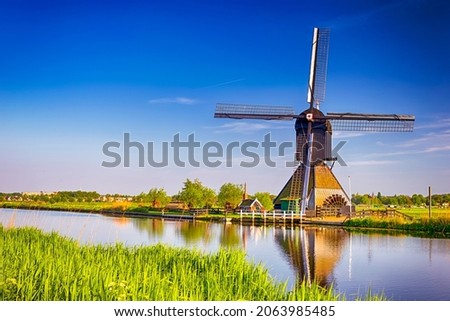 Traveling In The Netherlands. View of Traditional Romantic Dutch Windmills in Kinderdijk Village in the Netherlands Before Sunset. Horizontal Shot